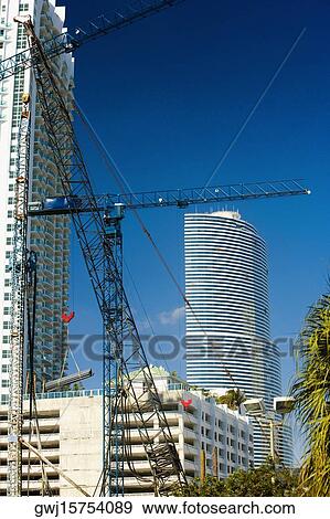 Low angle view of a crane in front of a skyscraper, Miami, Florida, USA View Large Photo Image Stock Photo - Low angle view of a crane in front of a skyscraper, Miami, Florida, USA. Fotosearch
