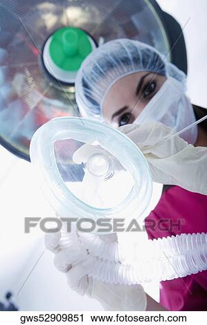 Low angle view of a female surgeon holding an oxygen mask View Large Photo Image Stock Image - Low angle view of a female surgeon holding an oxygen mask. Fotosearch