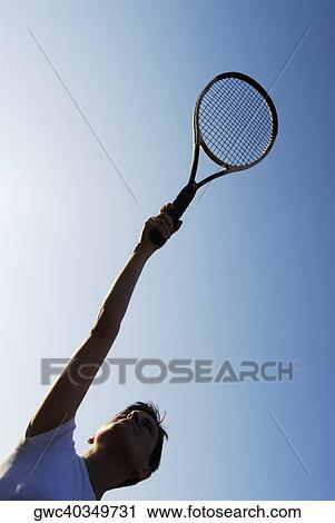 Low angle view of a mid adult woman holding a tennis racket View Large Photo Image Stock Image - Low angle view of a mid adult woman holding a tennis racket. Fotosearch