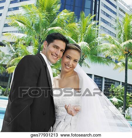Low angle view of a newlywed couple smiling View Large Photo Image Stock Image - Low angle view of a newlywed couple smiling. Fotosearch