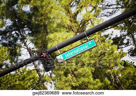 Low angle view of a sign board hanging on a traffic pole View Large Photo Image Stock Photo - Low angle view of a sign board hanging on a traffic pole. Fotosearch