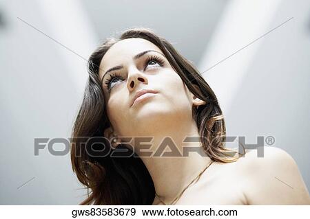 Stock Photo - Low angle view of a young woman looking serious. Fotosearch