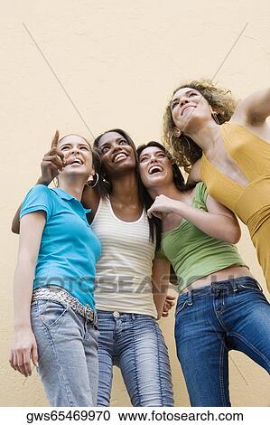 Low angle view of four teenage girls pointing up View Large Photo Image Stock Image - Low angle view of four teenage girls pointing up. Fotosearch