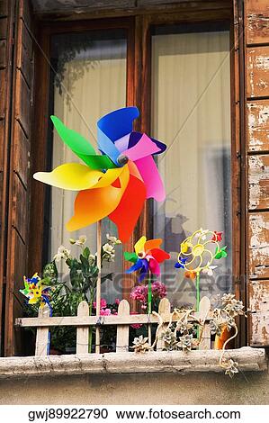 Low angle view of pinwheels with flower vases in front of a window View Large Photo Image Stock Image - Low angle view of pinwheels with flower vases in front of a window. Fotosearch