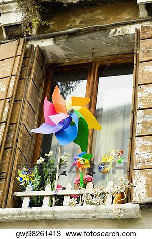Low angle view of pinwheels with flower vases in front of a window View Large Photo Image Stock Image - Low angle view of pinwheels with flower vases in front of a window. Fotosearch