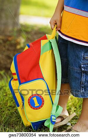Low section view of a boy carrying a schoolbag View Large Photo Image Picture - Low section view of a boy carrying a schoolbag. Fotosearch