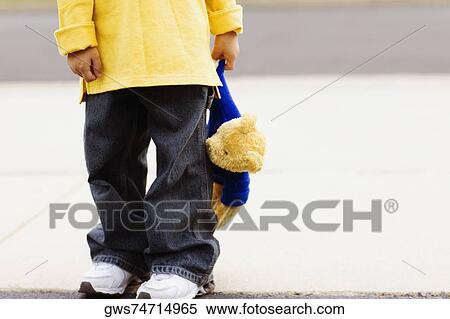 Low section view of a boy holding a teddy bear View Large Photo Image Stock Photography - Low section view of a boy holding a teddy bear. Fotosearch