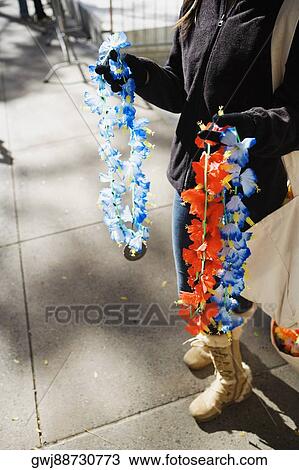 Stock Image - Low section view of a man selling garlands. Fotosearch