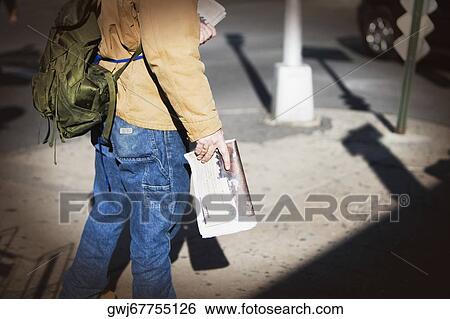 Stock Photograph - Low section view of a man selling newspapers. Fotosearch