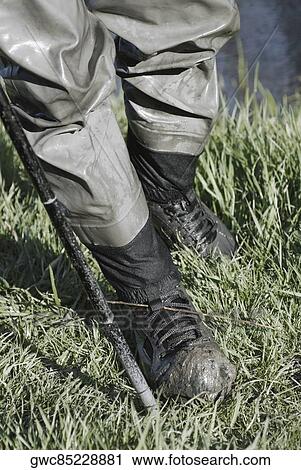 Stock Image - Low section view of a man standing on the grass. Fotosearch