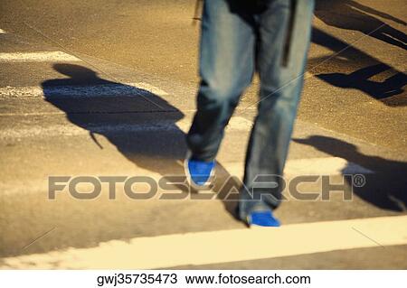 Low section view of a man walking on the road View Large Photo Image Stock Image - Low section view of a man walking on the road. Fotosearch