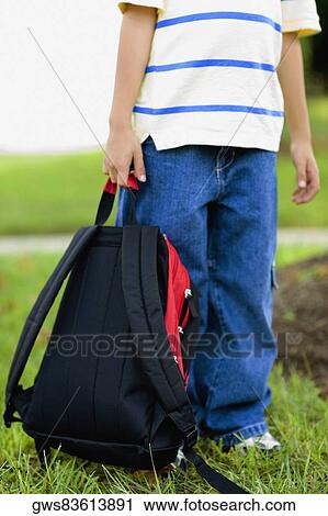 Low section view of a schoolboy carrying a schoolbag View Large Photo Image Stock Image - Low section view of a schoolboy carrying a schoolbag. Fotosearch