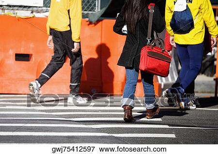 Low section view of a woman and two men walking on the road View Large Photo Image Stock Photo - Low section view of a woman and two men walking on the road. Fotosearch