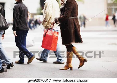 Low section view of four people walking together and carrying bags View Large Photo Image Stock Photo - Low section view of four people walking together and carrying bags. Fotosearch