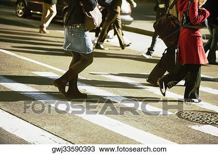 Low section view of men and women walking on the road View Large Photo Image Stock Image - Low section view of men and women walking on the road. Fotosearch
