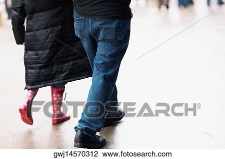 Stock Image - Low section view of two people walking. Fotosearch
