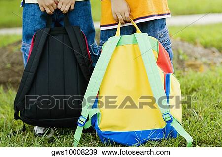 Low section view of two schoolboys carrying schoolbags View Large Photo Image Stock Photo - Low section view of two schoolboys carrying schoolbags. Fotosearch