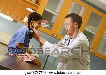 Male doctor examining a girl View Large Photo Image Stock Image - Male doctor examining a girl. Fotosearch