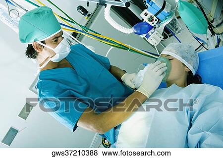Male surgeon putting an oxygen mask on a female patient View Large Photo Image Stock Photo - Male surgeon putting an oxygen mask on a female patient. Fotosearch