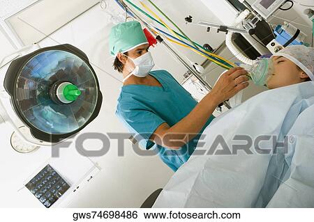 Male surgeon putting an oxygen mask on the mouth of a female patient View Large Photo Image Stock Photograph - Male surgeon putting an oxygen mask on the mouth of a female patient. Fotosearch