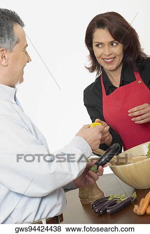Mid adult couple making salad View Large Photo Image Stock Photo - Mid adult couple making salad. Fotosearch