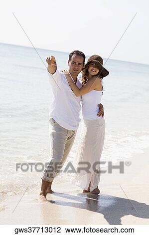 Mid adult man and a young woman standing on the beach View Large Photo Image Stock Image - Mid adult man and a young woman standing on the beach. Fotosearch