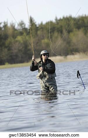 Mid adult man fishing in the river View Large Photo Image Picture - Mid adult man fishing in the river. Fotosearch