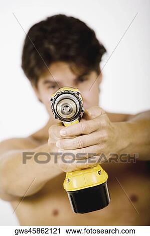 Mid adult man holding a drill machine View Large Photo Image Stock Image - Mid adult man holding a drill machine. Fotosearch
