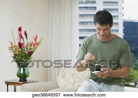 Mid adult man stirring tea with a teaspoon View Large Photo Image Stock Photo - Mid adult man stirring tea with a teaspoon. Fotosearch