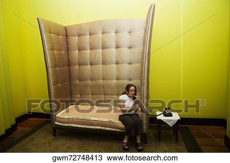 Mid adult woman sitting in an armchair and talking on a rotary phone View Large Photo Image Stock Image - Mid adult woman sitting in an armchair and talking on a rotary phone. Fotosearch
