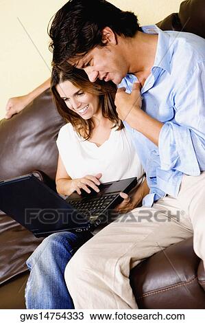 Mid adult woman using a laptop with a mid adult man sitting beside her View Large Photo Image Stock Image - Mid adult woman using a laptop with a mid adult man sitting beside her. Fotosearch