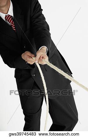 Mid section view of a businessman pulling a rope View Large Photo Image Stock Image - Mid section view of a businessman pulling a rope. Fotosearch