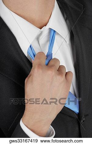 Mid section view of a businessman pulling his tie View Large Photo Image Stock Photo - Mid section view of a businessman pulling his tie. Fotosearch