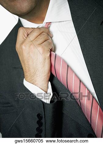 Mid section view of a businessman adjusting his tie View Large Photo Image Stock Photography - Mid section view of a businessman adjusting his tie. Fotosearch