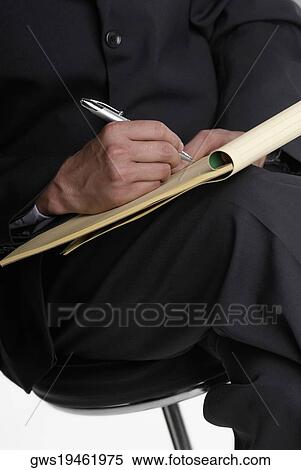 Mid section view of a businessman sitting on a stool and writing on a notepad View Large Photo Image Stock Photography - Mid section view of a businessman sitting on a stool and writing on a notepad. Fotosearch
