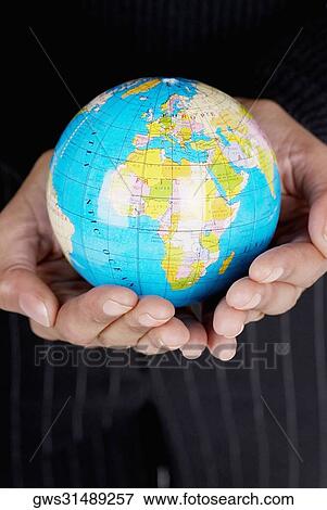 Mid section view of a businesswoman holding a globe View Large Photo Image Stock Photo - Mid section view of a businesswoman holding a globe. Fotosearch