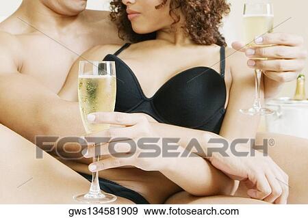 Mid section view of a man and woman holding a glass View Large Photo Image Stock Photo - Mid section view of a man and woman holding a glass. Fotosearch