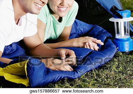 Mid section view of a man and woman lying in a tent View Large Photo Image Stock Photo - Mid section view of a man and woman lying in a tent. Fotosearch