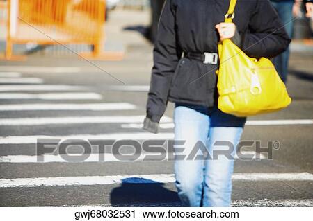 Mid section view of a man carrying a bag and walking on the road View Large Photo Image Stock Image - Mid section view of a man carrying a bag and walking on the road. Fotosearch