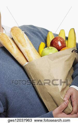 Mid section view of a man holding a shopping bag View Large Photo Image Stock Image - Mid section view of a man holding a shopping bag. Fotosearch