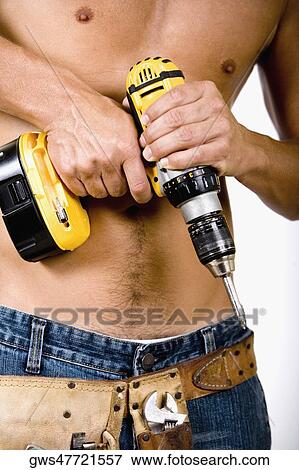 Mid section view of a man holding a drill machine View Large Photo Image Stock Photo - Mid section view of a man holding a drill machine. Fotosearch