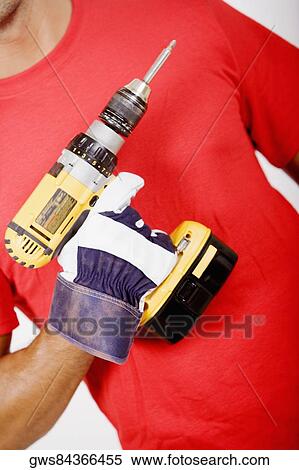 Mid section view of a man holding a drill machine View Large Photo Image Stock Photography - Mid section view of a man holding a drill machine. Fotosearch