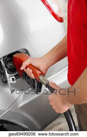Mid section view of a man refueling a car View Large Photo Image Stock Photograph - Mid section view of a man refueling a car. Fotosearch