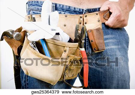 Stock Photo - Mid section view of a man wearing a tool belt. Fotosearch