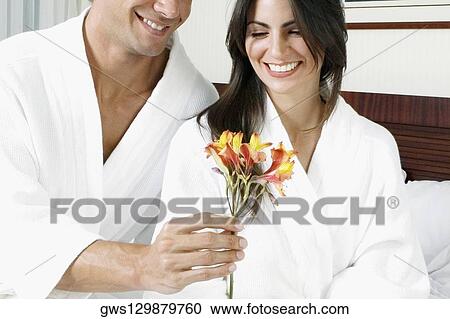 Mid section view of a mid adult man giving flowers to a mid adult woman View Large Photo Image Stock Image - Mid section view of a mid adult man giving flowers to a mid adult woman. Fotosearch