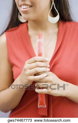 Mid section view of a teenage girl holding an ice lolly View Large Photo Image Stock Image - Mid section view of a teenage girl holding an ice lolly. Fotosearch