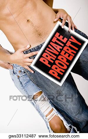 Stock Photo - Mid section view of a woman holding a Private Property sign in front of a man's crotch. Fotosearch