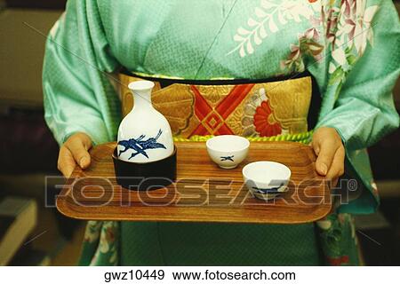 Mid section view of a woman holding saki on tray, Japan View Large Photo Image Stock Photo - Mid section view of a woman holding saki on tray, Japan. Fotosearch