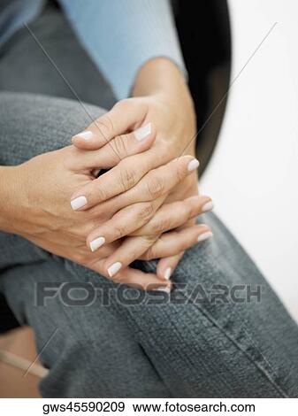 Mid section view of a woman sitting with her legs crossed at the knee View Large Photo Image Stock Photo - Mid section view of a woman sitting with her legs crossed at the knee. Fotosearch