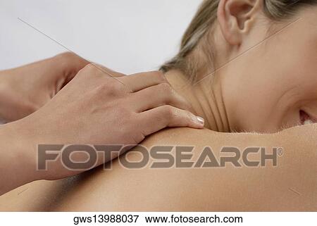 Mid section view of a young woman getting a massage View Large Photo Image Stock Photo - Mid section view of a young woman getting a massage. Fotosearch